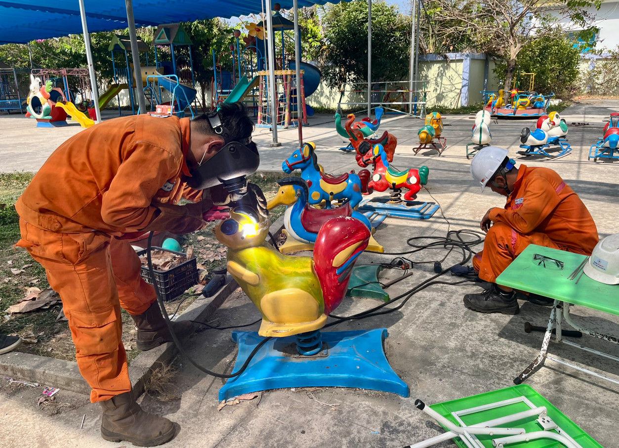 A group of people welding on a carouselDescription automatically generated